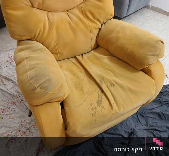 כורסה צהובה עם כתמים על בד הכיסוי